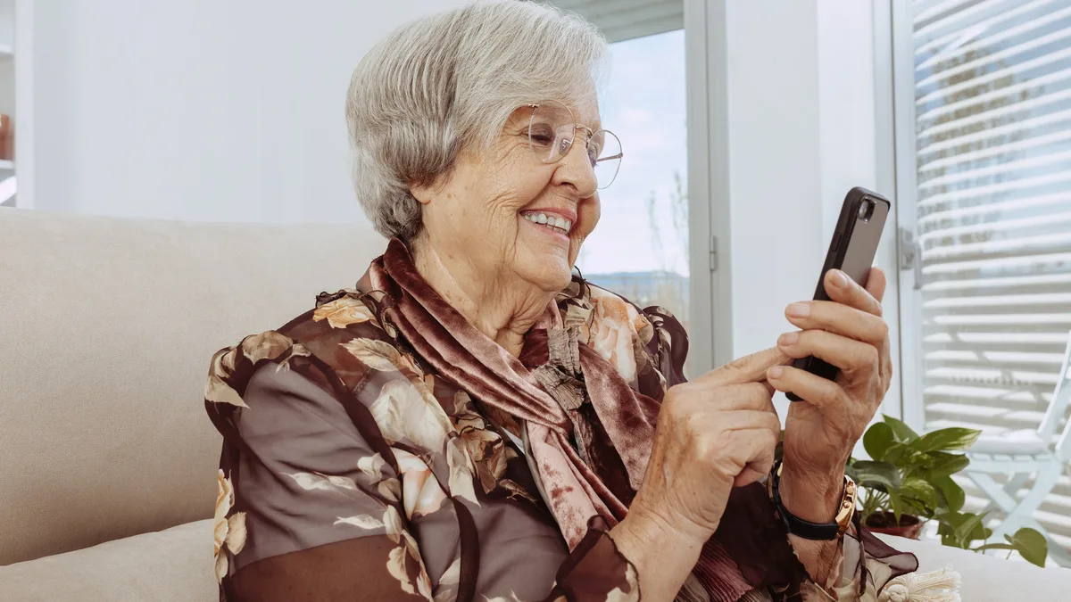 Une femme âgée utilisant son téléphone portable chez elle