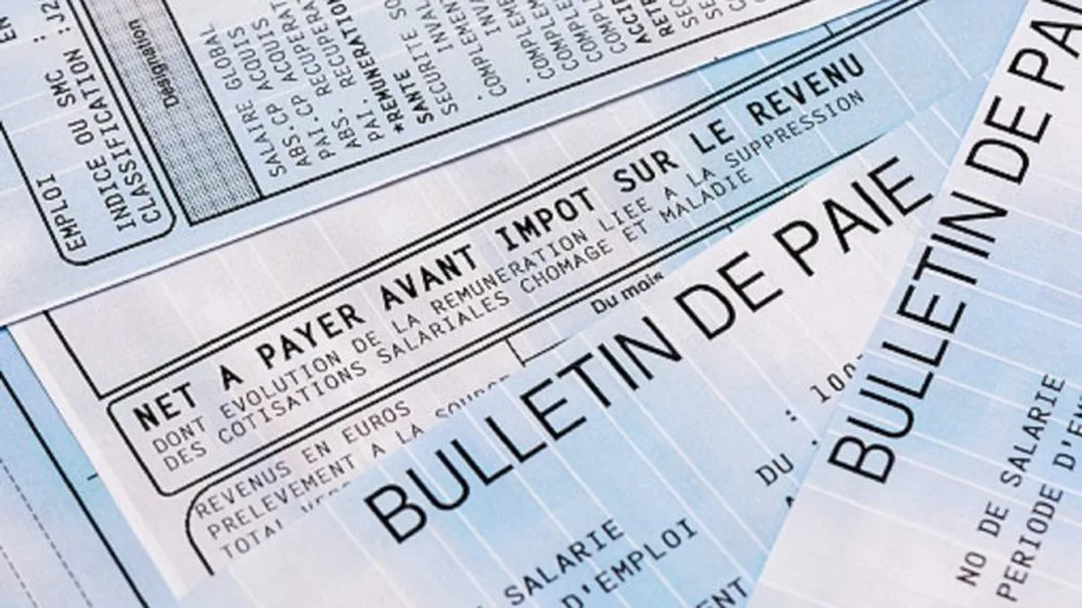 Salarié vérifiant sa fiche de paie à son bureau