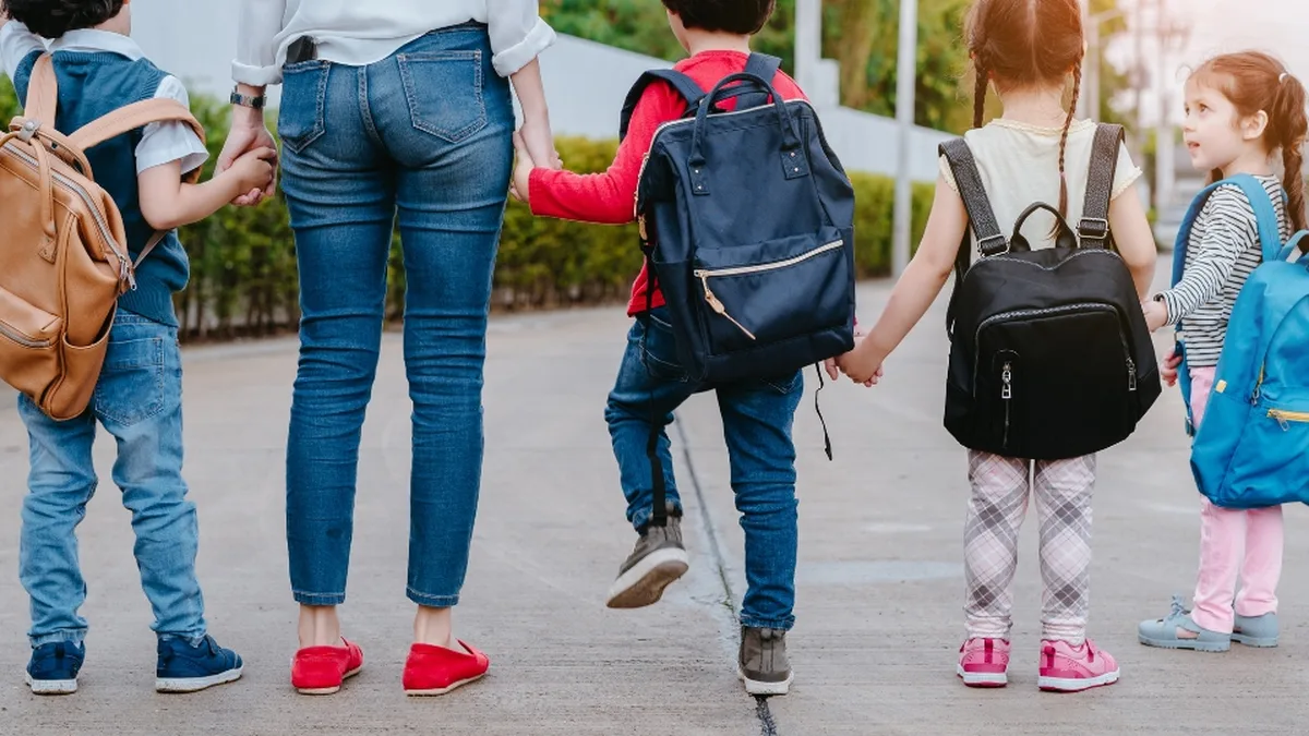 Une famille avec deux enfants dans un parc, illustration des allocations familiales