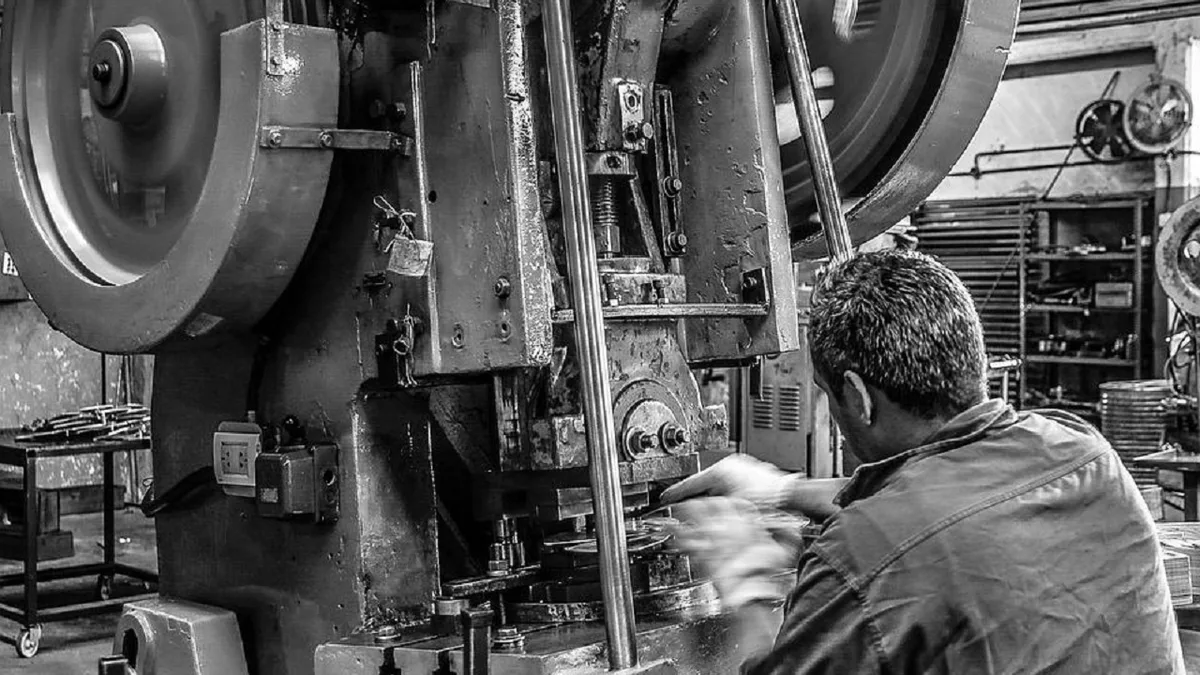 Un ouvrier sur une presse en usine