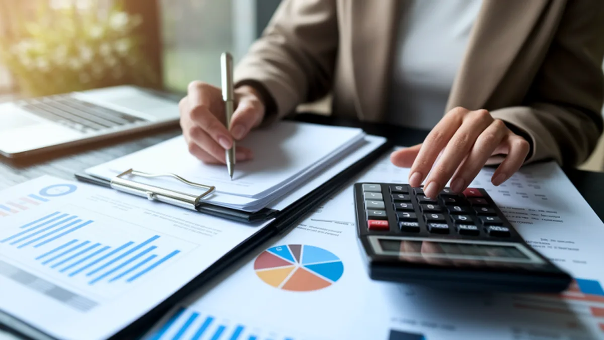 Personne vérifiant des factures avec une calculatrice