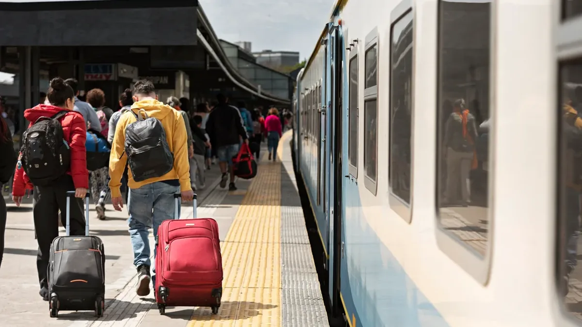 Des voyageurs avec leurs valises dans une gare, prêts pour les fêtes