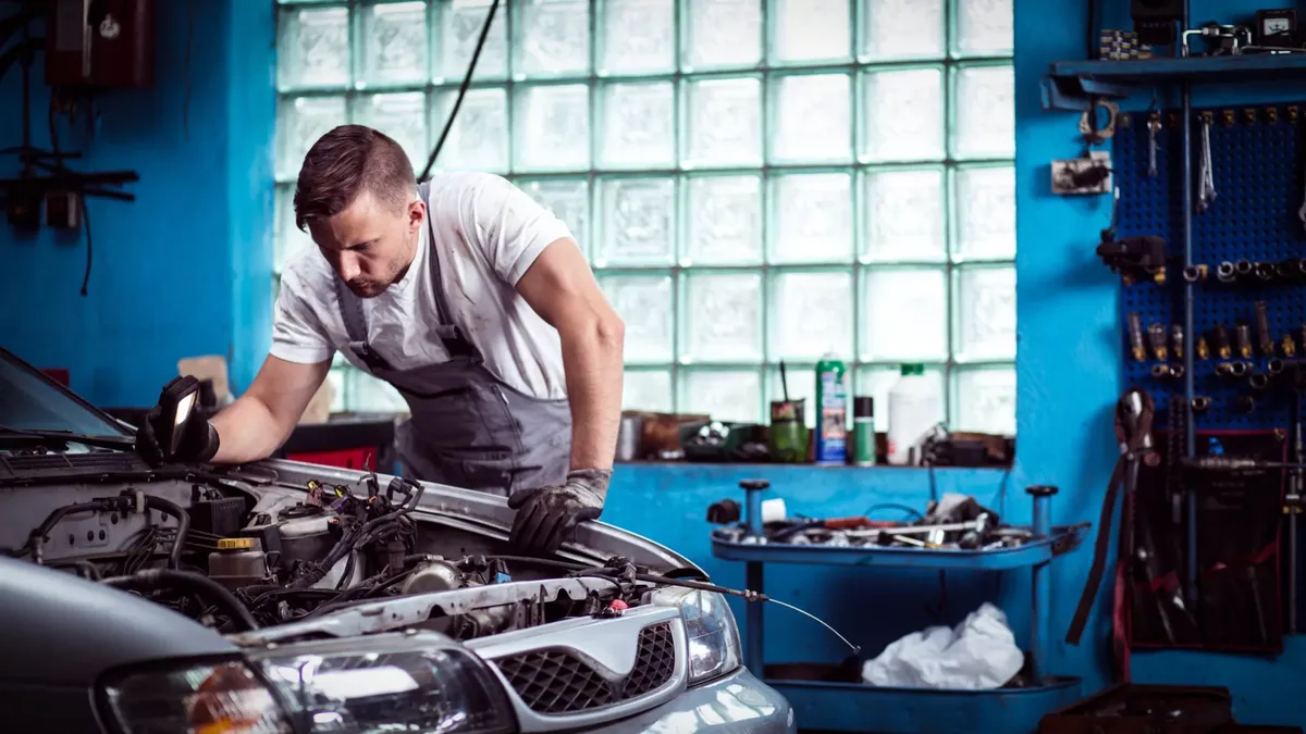 Mécanicien travaillant sur le moteur d&rsquo;une voiture dans un garage