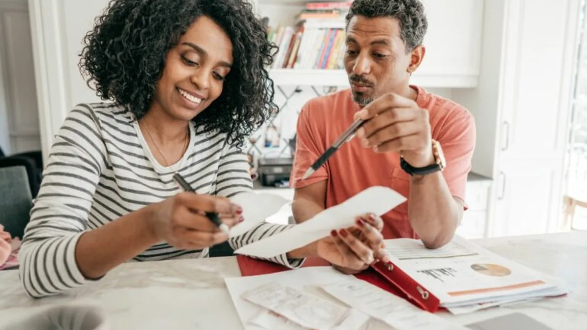 Un couple vérifie ses factures à la table de la cuisine