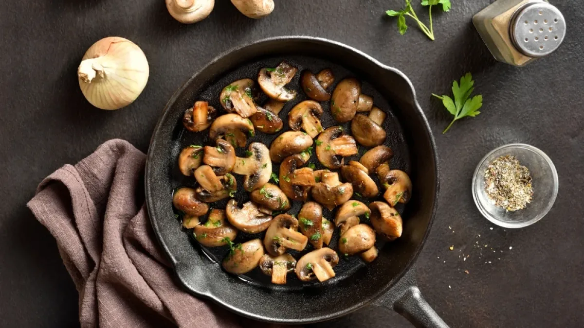 Une poêlée de champignons au persil dans une poêle en fonte