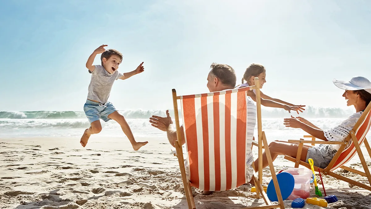 Une famille joue sur la plage avec des jeux de sable, en vacances