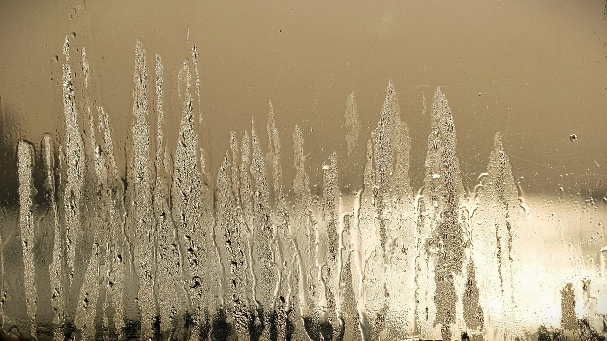 Fenêtre blanche couverte de buée au petit matin d&rsquo;automne