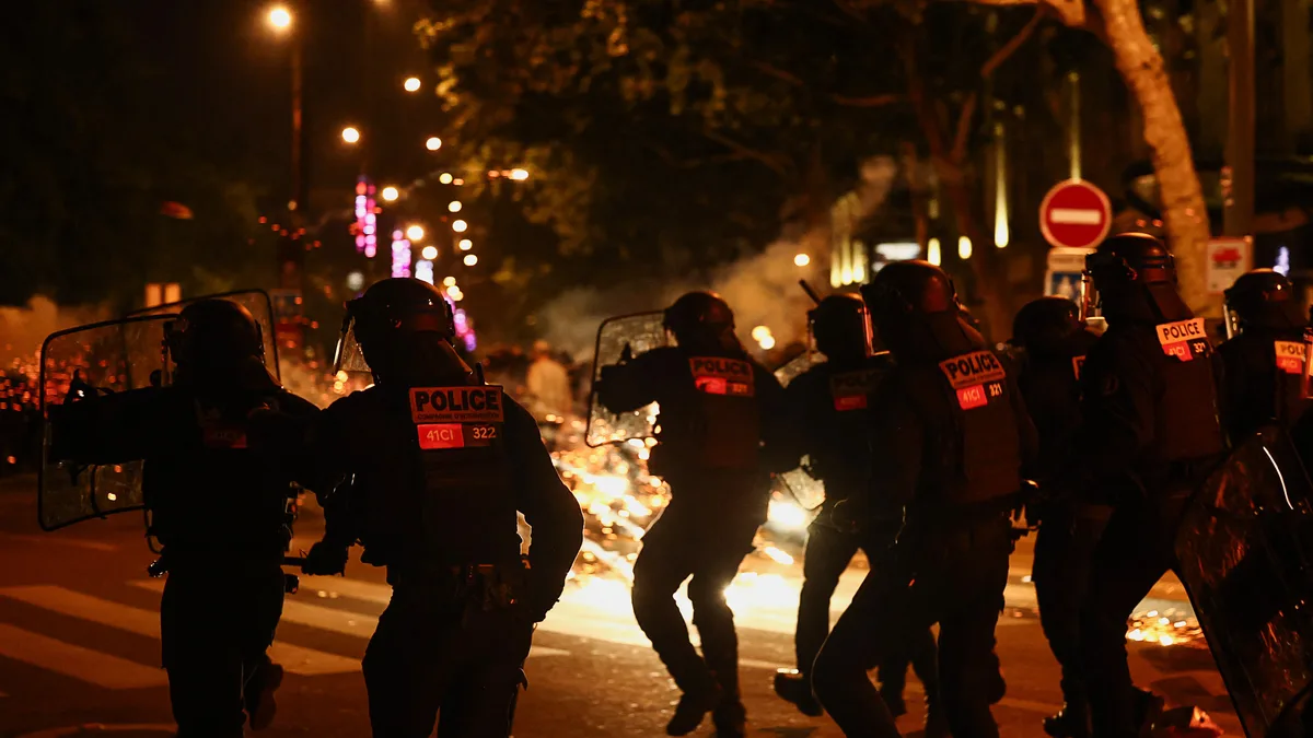 Charge de policiers la nuit lors d&rsquo;affrontements, au milieu des incendies