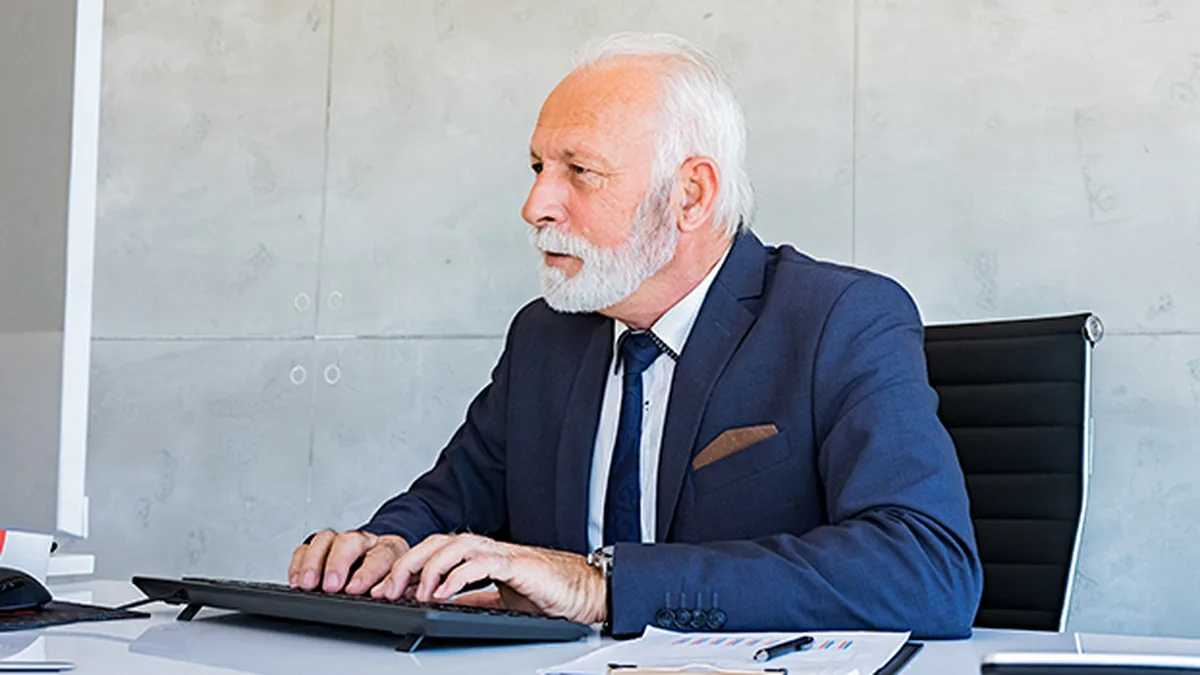 Un senior au travail dans un bureau, illustrant le cumul emploi-retraite