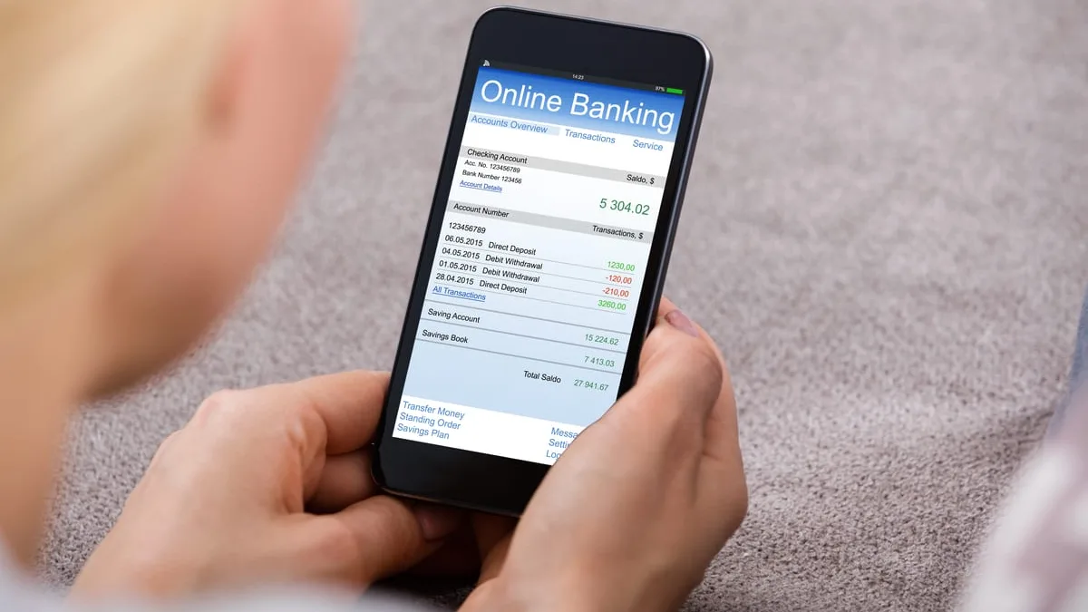 Une personne consulte son application bancaire sur smartphone