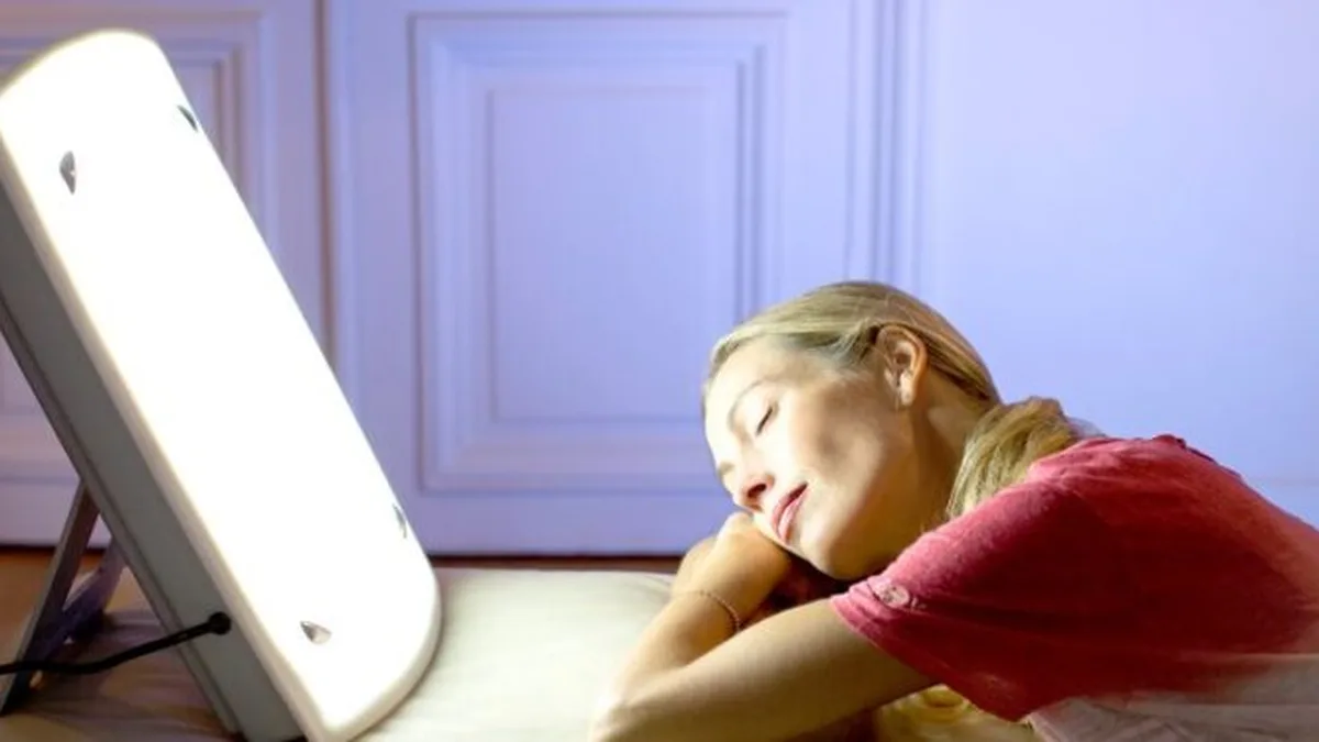 Une femme utilisant une lampe de luminothérapie le matin