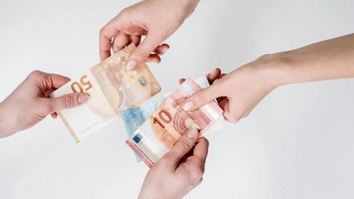 Des mains échangent des billets en euros