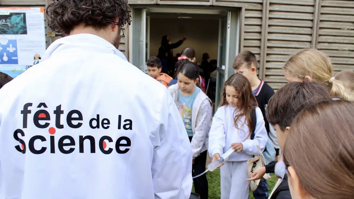 Un médiateur en blouse Fête de la science accueille des enfants