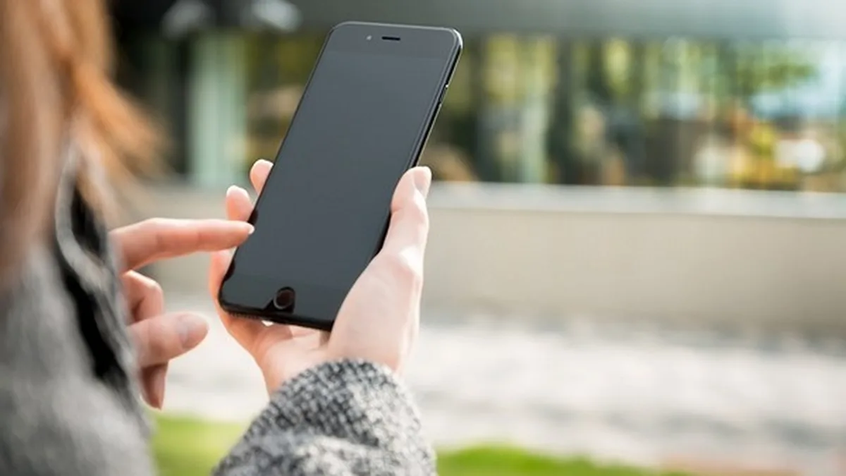 Une cliente tient son smartphone : beaucoup ont changé de téléphone pour la 5G promise en 2021