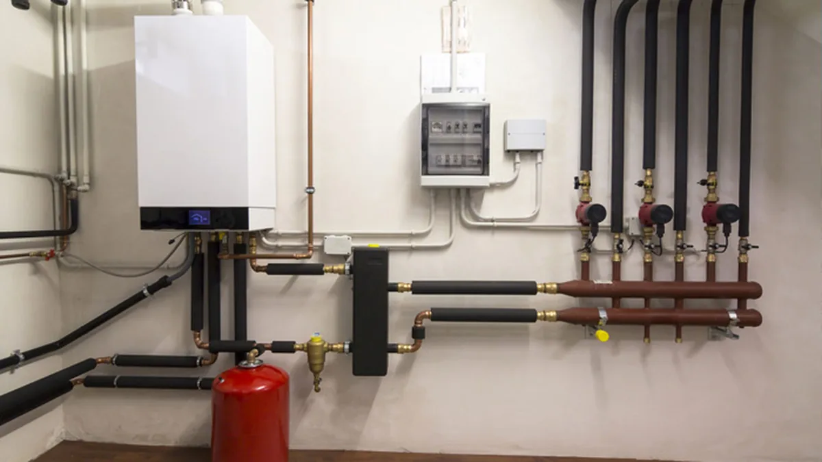 Une chaudière gaz murale et ses tuyaux dans une maison