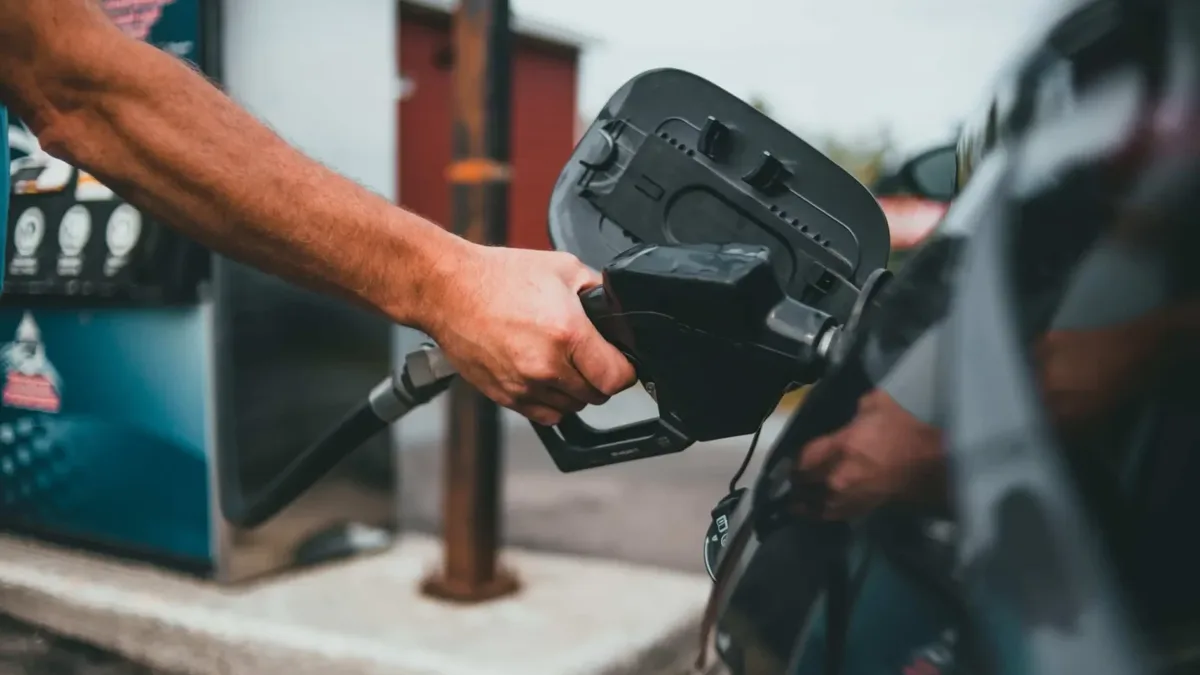 Un automobiliste fait le plein de sa voiture dans une station-service