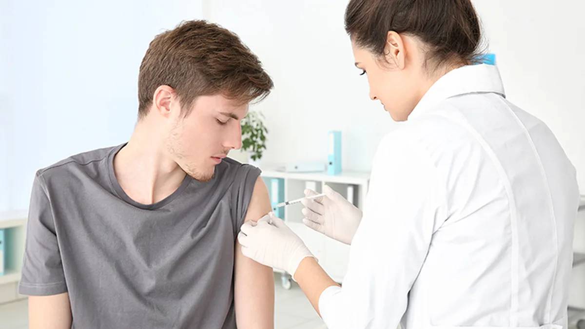 Une pharmacienne vaccine un patient en officine