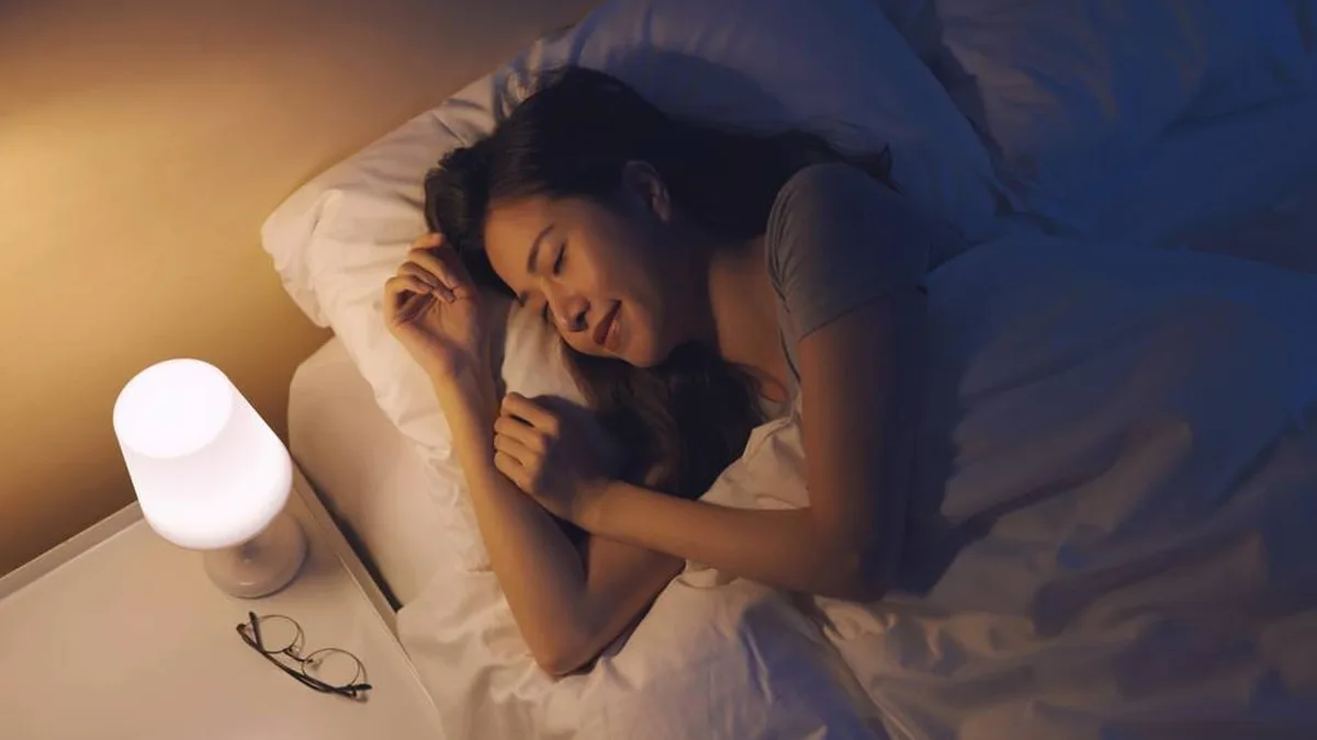 Une femme dort paisiblement dans une chambre plongée dans la pénombre