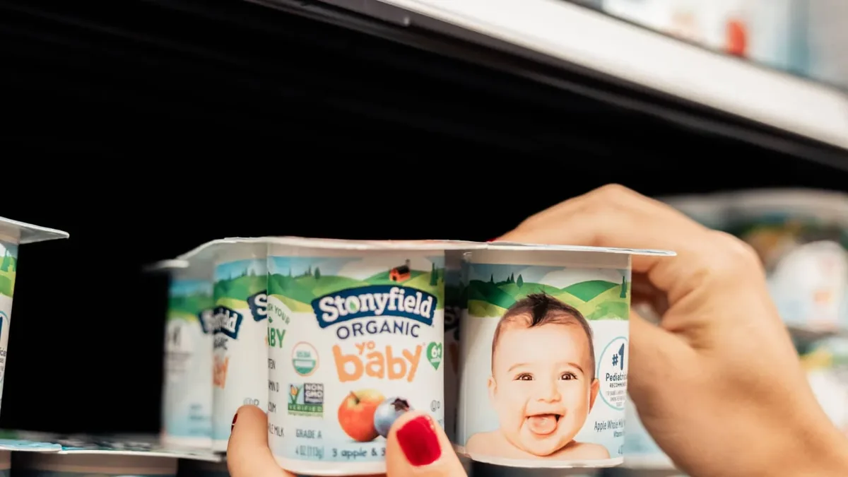 Une mère choisit des produits pour bébé dans un supermarché