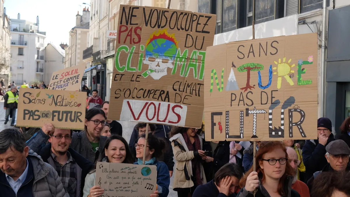 Des manifestants brandissent des pancartes lors d&rsquo;une marche pour le climat