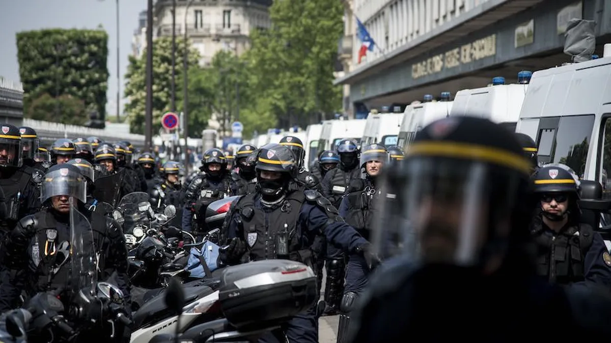 Des CRS déployés dans une rue, près de leurs véhicules