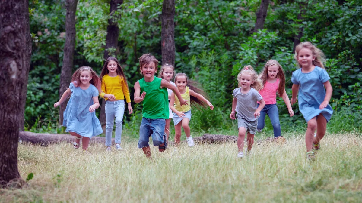 Des enfants courent dans l&rsquo;herbe lors d&rsquo;une colonie de vacances en plein air