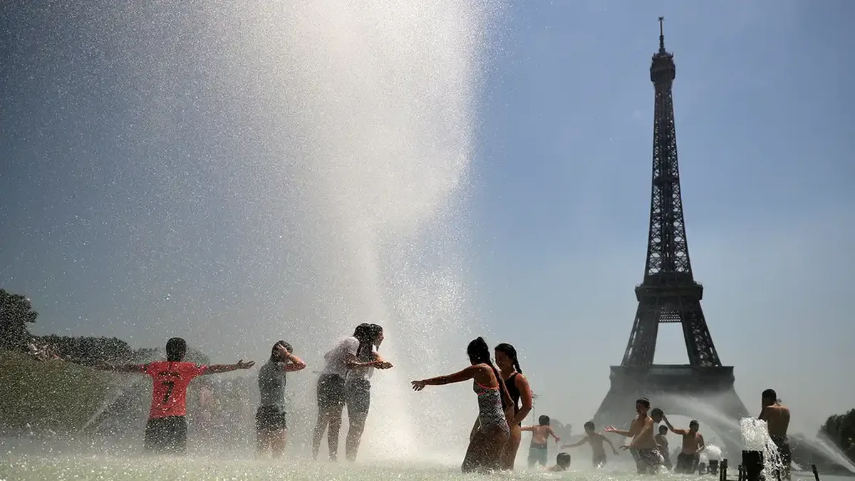 Des jeunes se rafraîchissent aux jets d&rsquo;eau du Trocadéro, à Paris