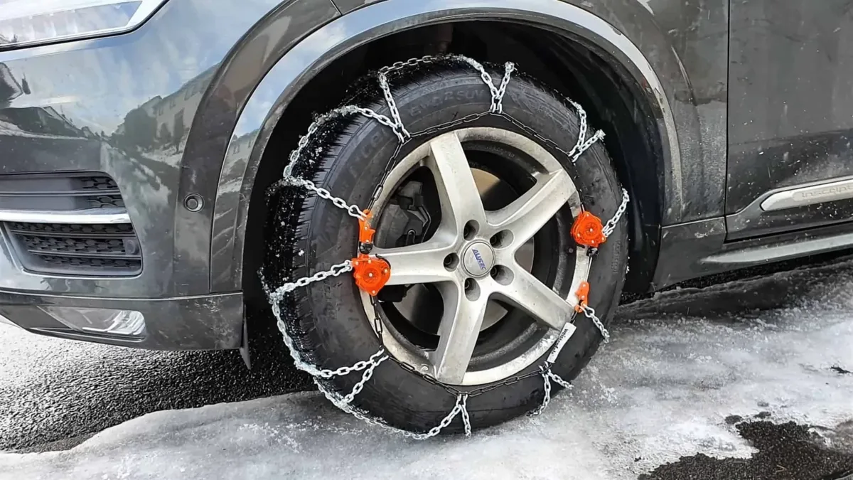 Des chaînes à neige montées sur une roue de voiture