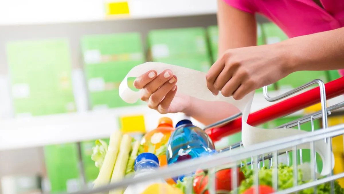 Une personne compare les prix dans les rayons d&rsquo;un supermarché