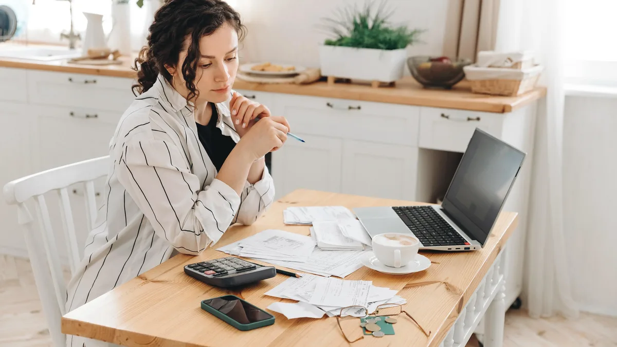 Une femme vérifie le montant de son ticket de caisse