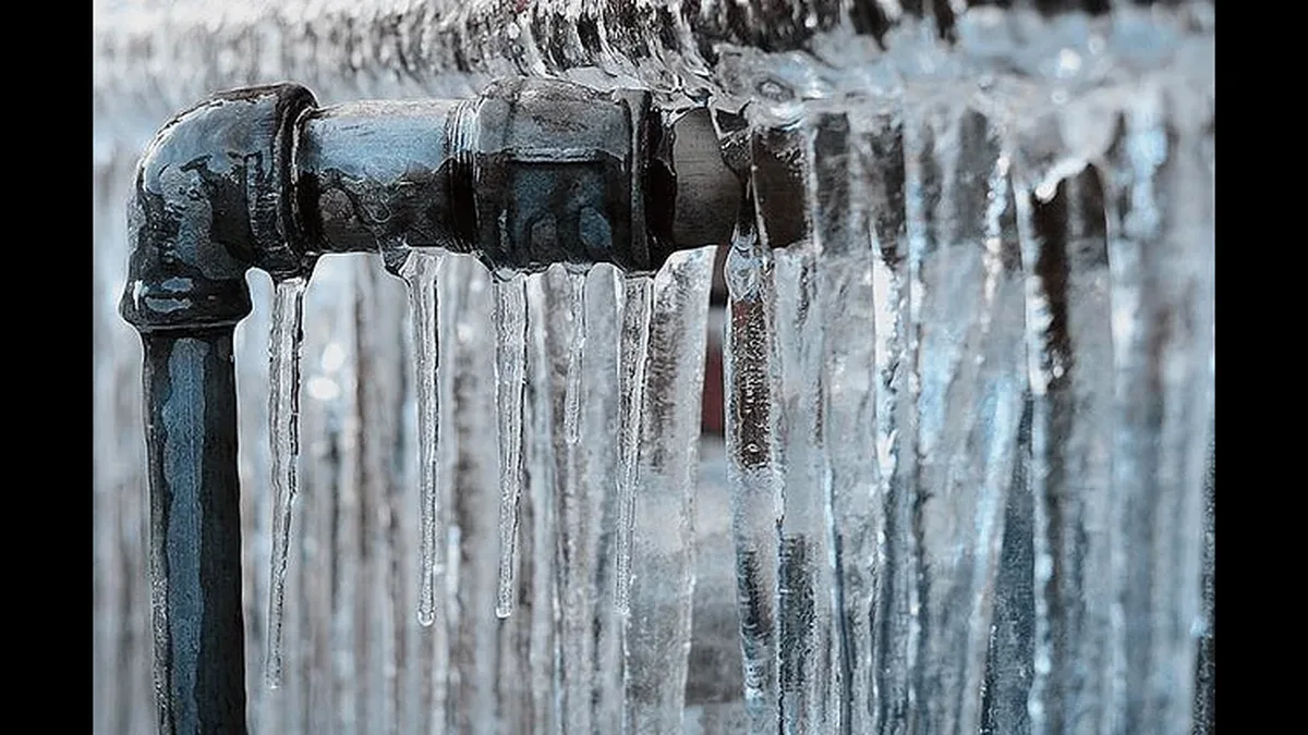 Tuyau couvert de glace et de stalactites en hiver
