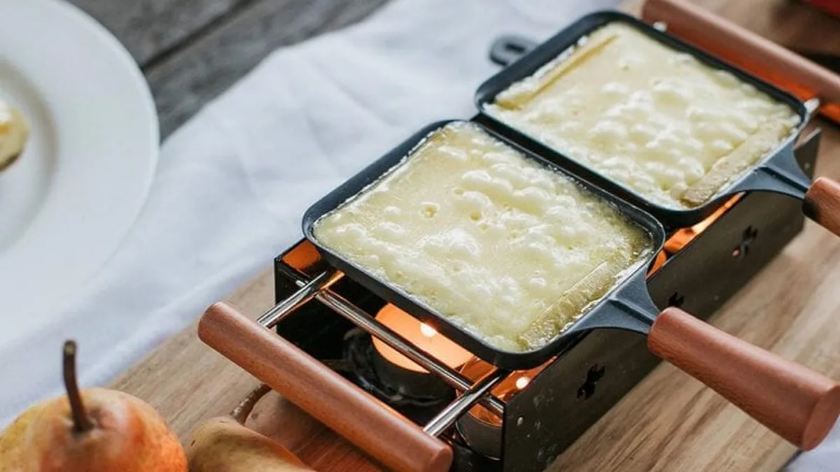 Poêlons de fromage fondant sur un appareil à raclette
