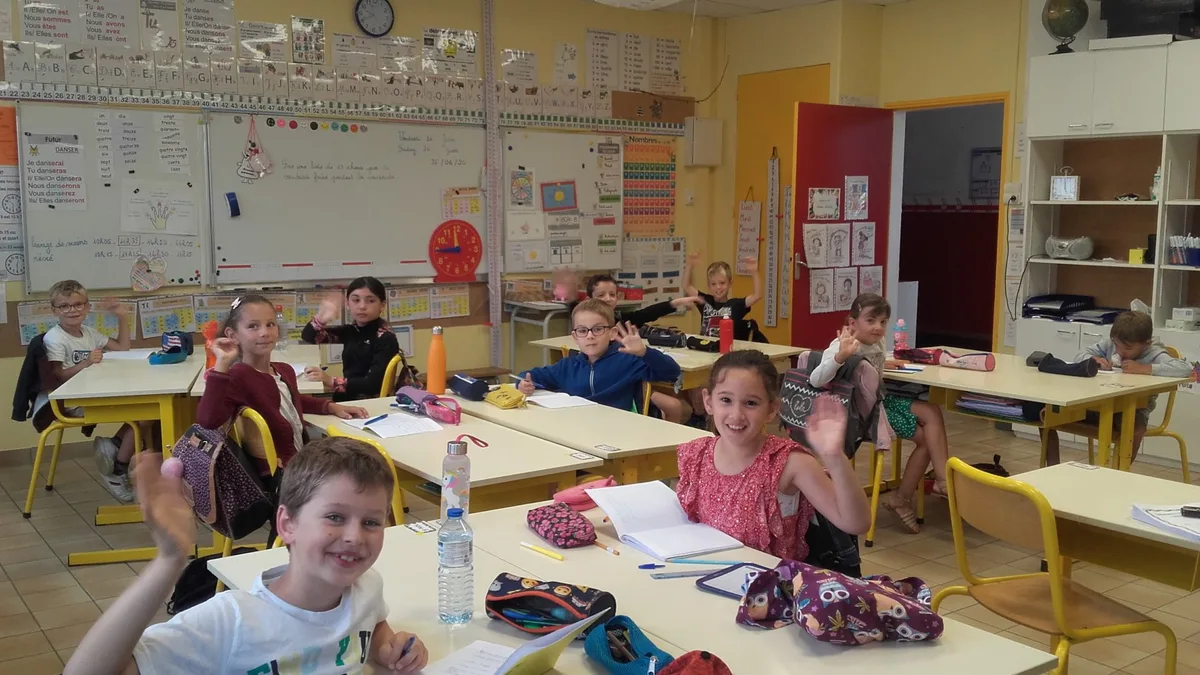 Des élèves dans la cour d&rsquo;une école, sacs sur le dos