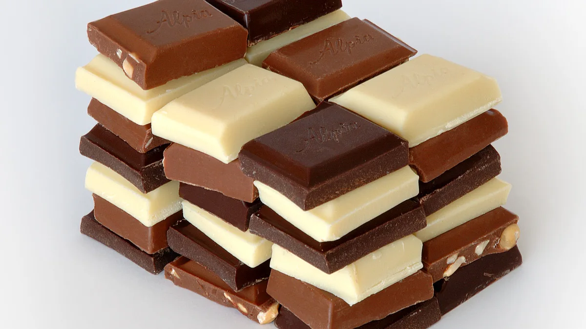 Des tablettes de chocolat au lait, noir et blanc empilées