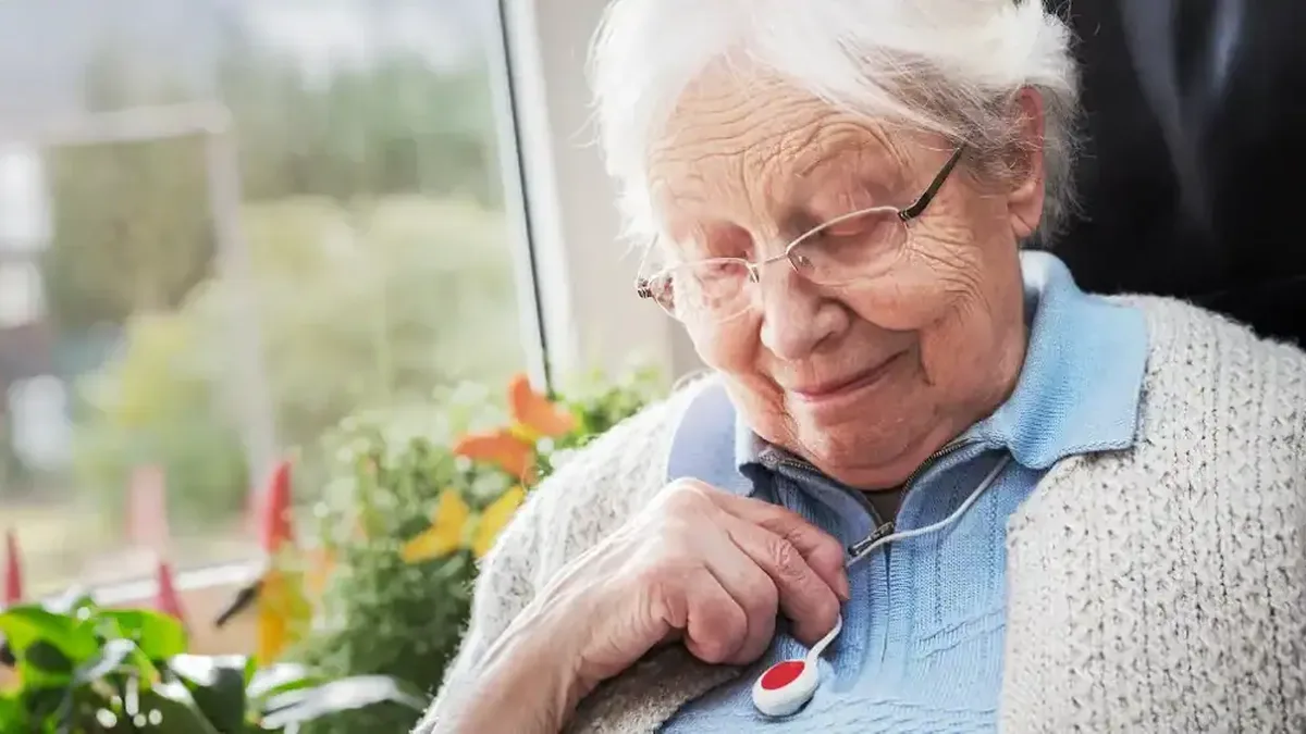 Une femme âgée appuie sur son médaillon de téléassistance