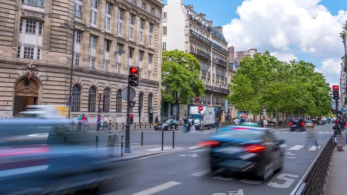 Une voiture s&rsquo;approche d&rsquo;un feu tricolore rouge en ville