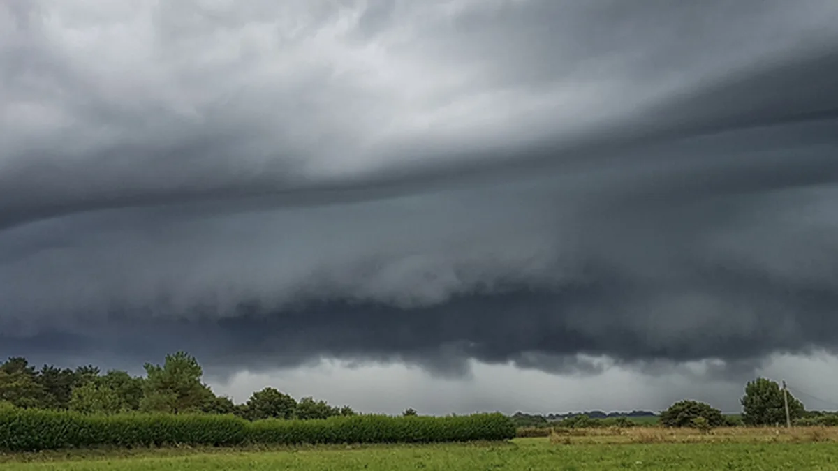 Ciel d&rsquo;orage menaçant au-dessus de la campagne, avec des éclairs au loin